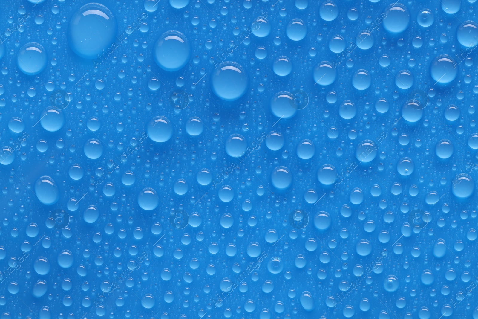 Photo of Water drops on blue background, top view