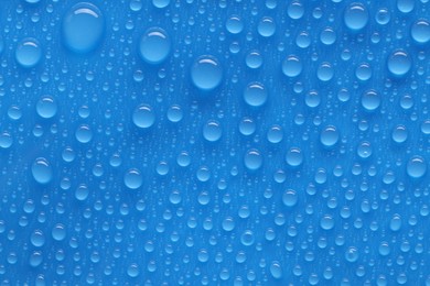 Photo of Water drops on blue background, top view