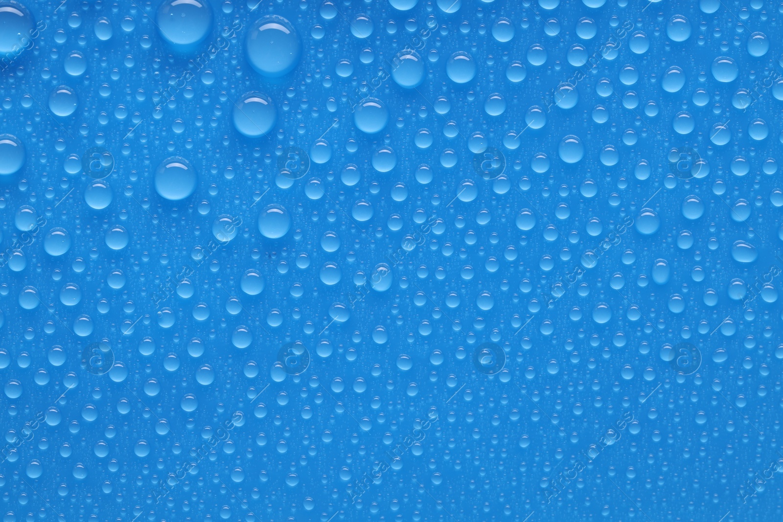 Photo of Water drops on blue background, top view