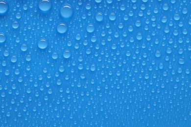 Photo of Water drops on blue background, top view