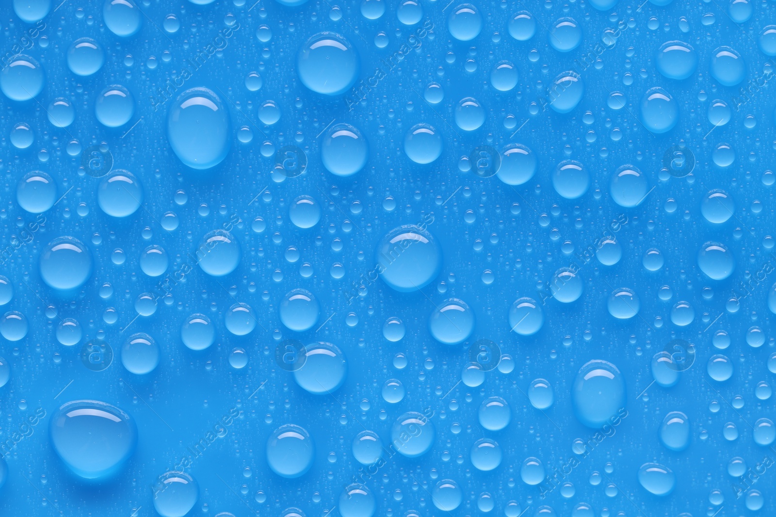 Photo of Water drops on blue background, top view