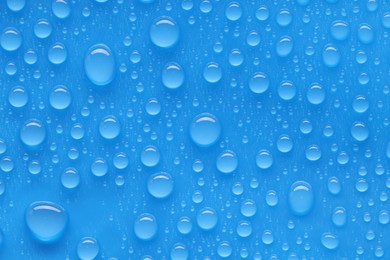 Photo of Water drops on blue background, top view