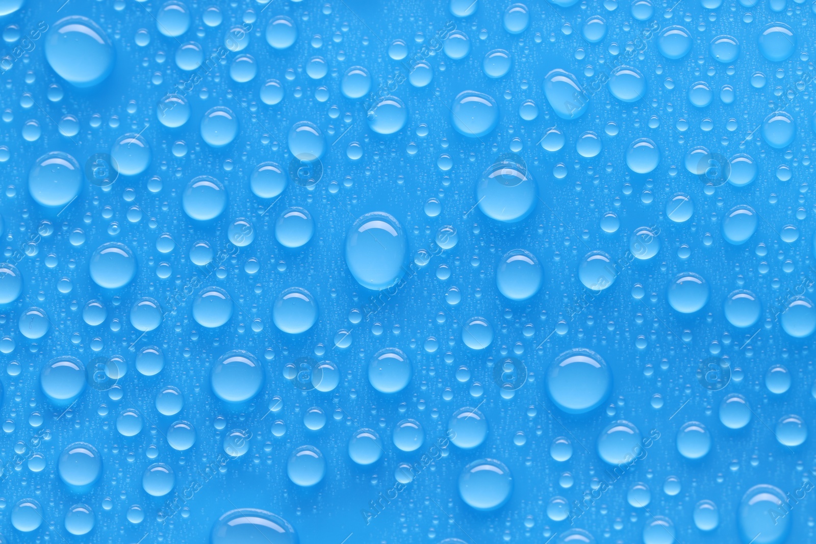 Photo of Water drops on blue background, top view