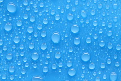 Photo of Water drops on blue background, top view