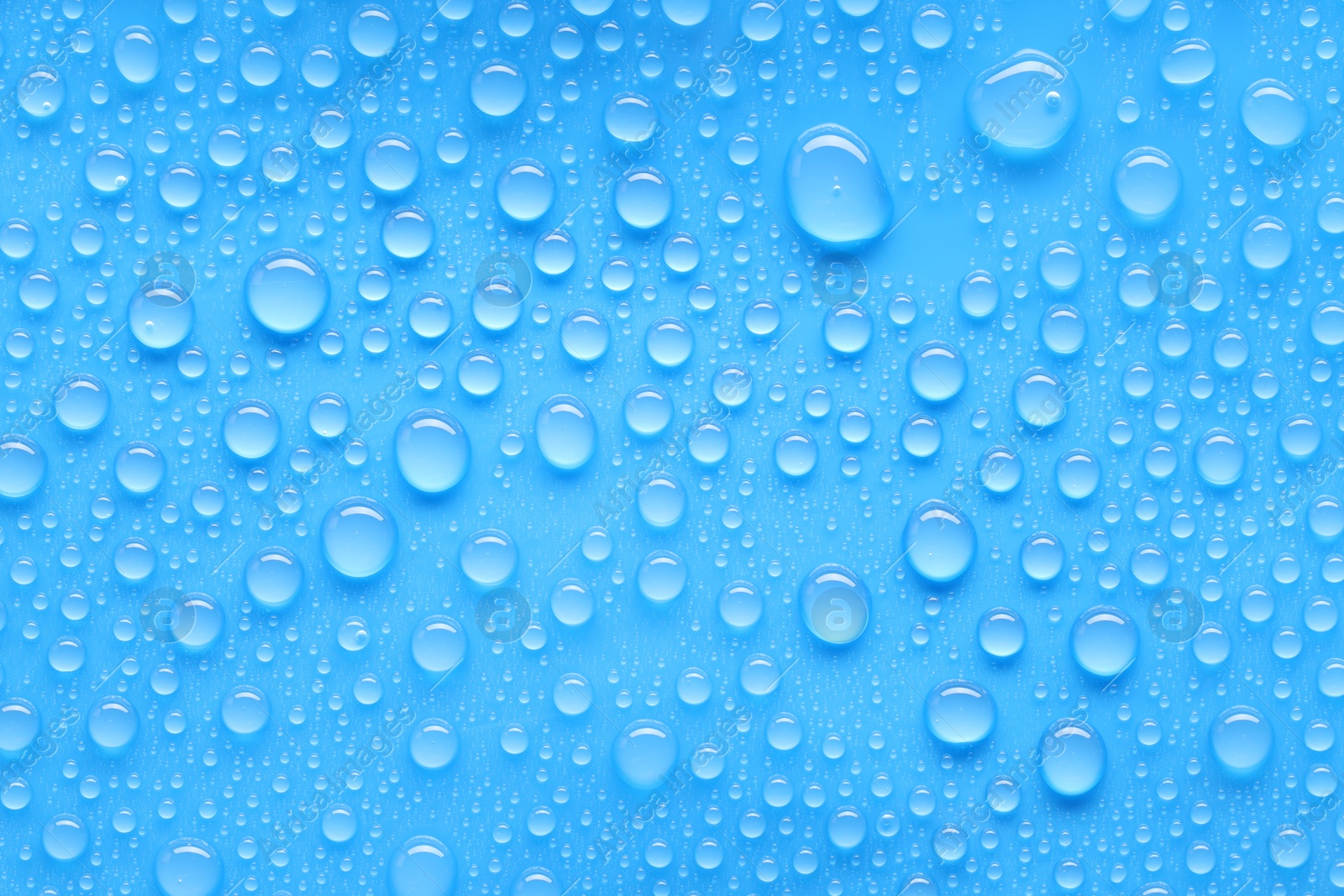 Photo of Water drops on blue background, top view