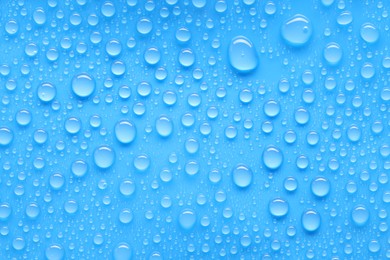 Photo of Water drops on blue background, top view