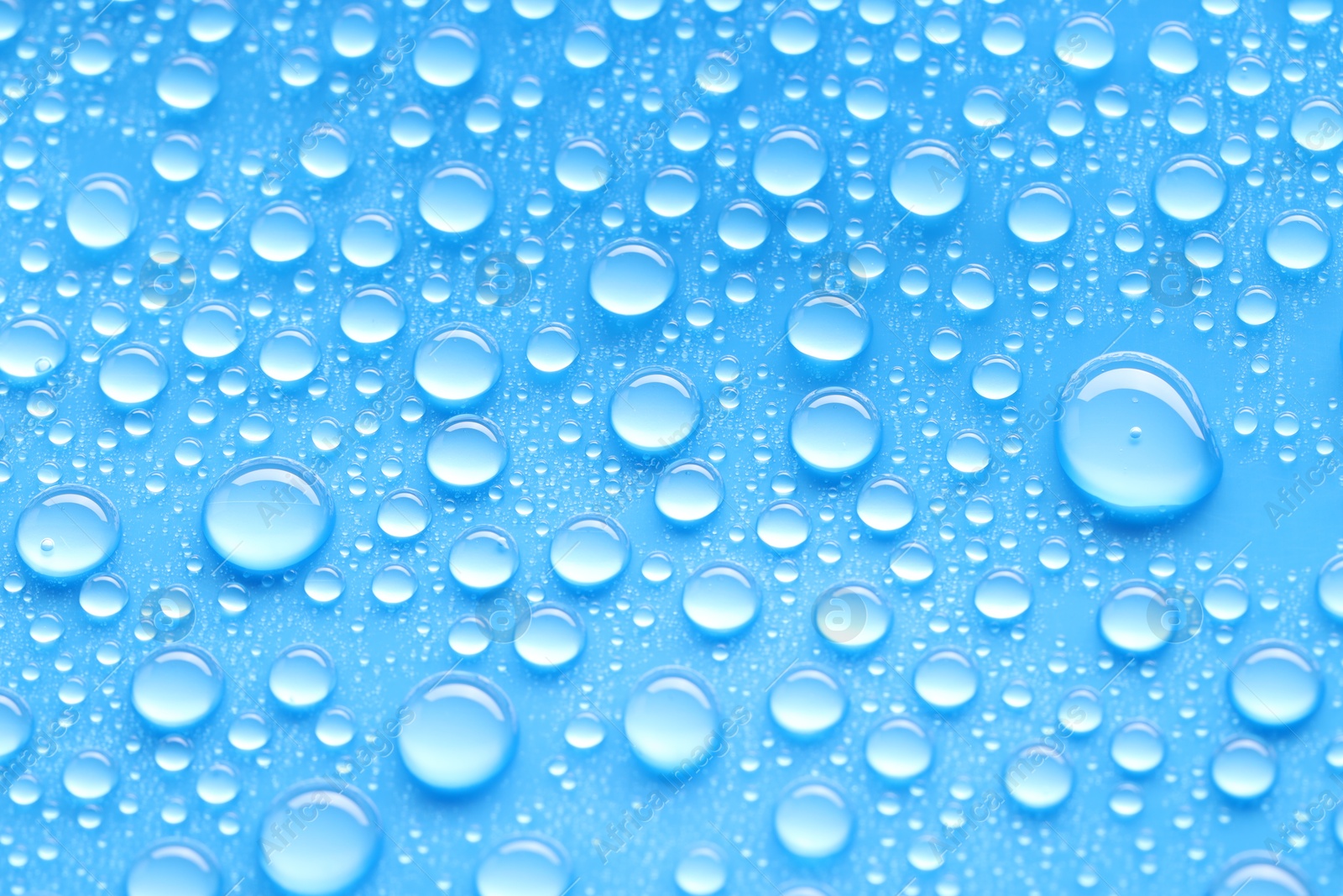 Photo of Water drops on blue background, top view