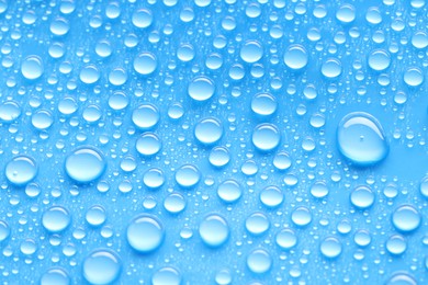 Photo of Water drops on blue background, top view