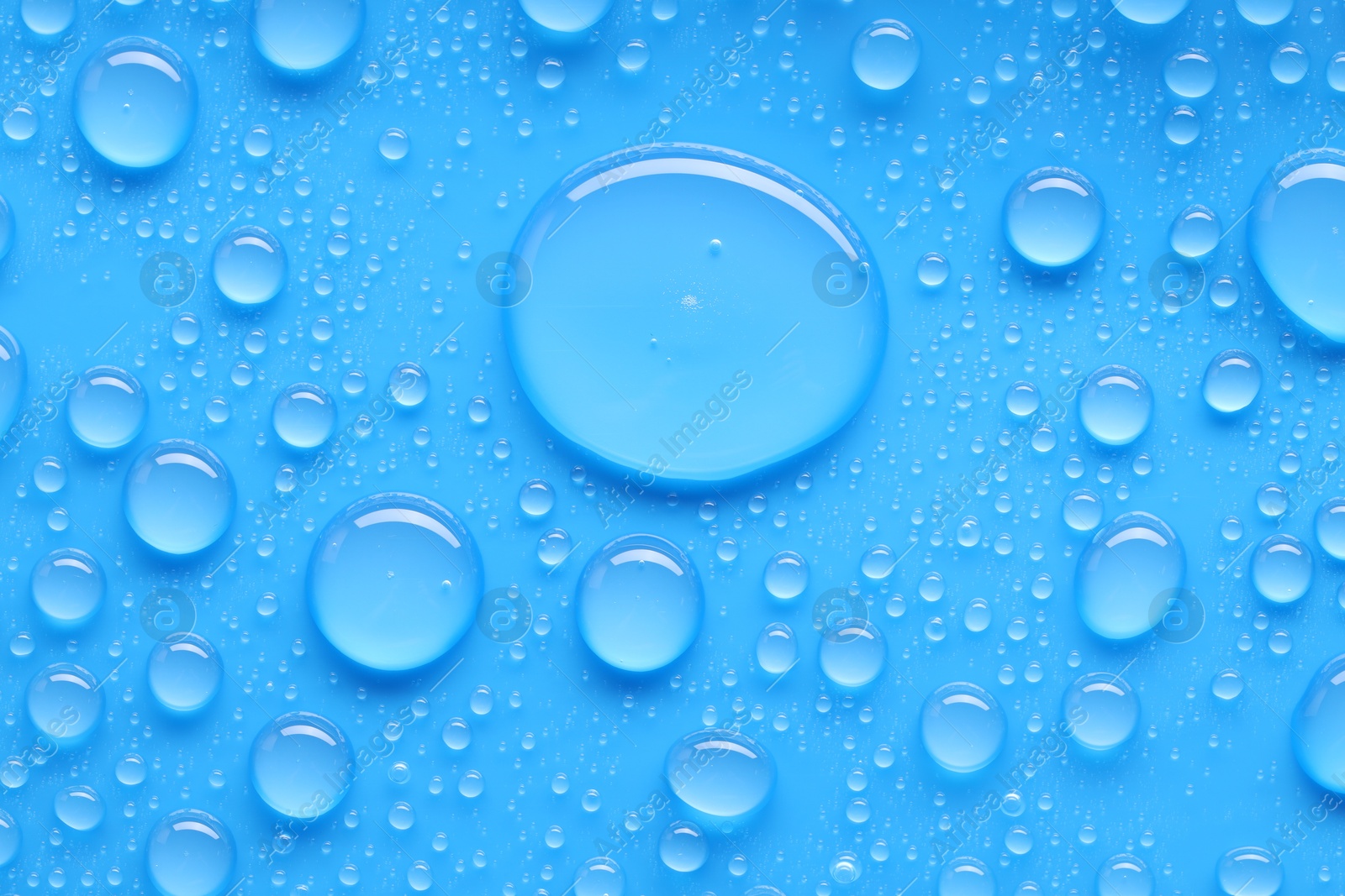 Photo of Water drops on blue background, top view