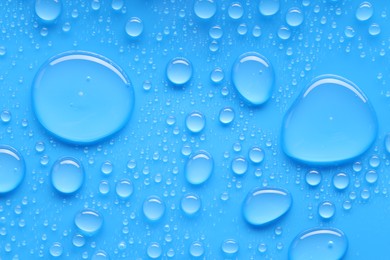 Photo of Water drops on blue background, top view