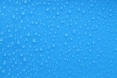 Photo of Water drops on blue background, top view