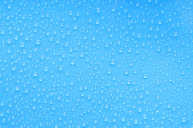 Photo of Water drops on blue background, top view