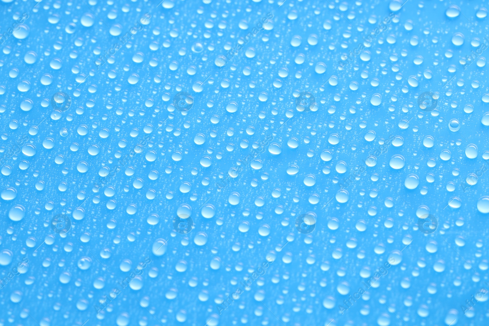 Photo of Water drops on blue background, top view