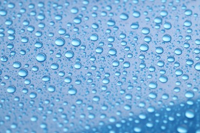 Photo of Water drops on blue background, closeup view