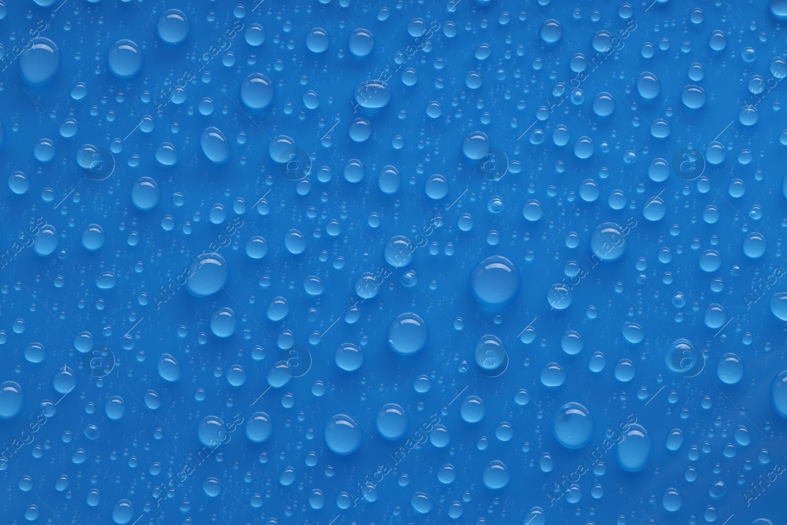 Photo of Water drops on blue background, top view