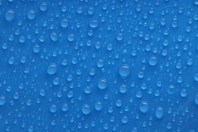 Photo of Water drops on blue background, top view