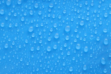 Photo of Water drops on blue background, top view