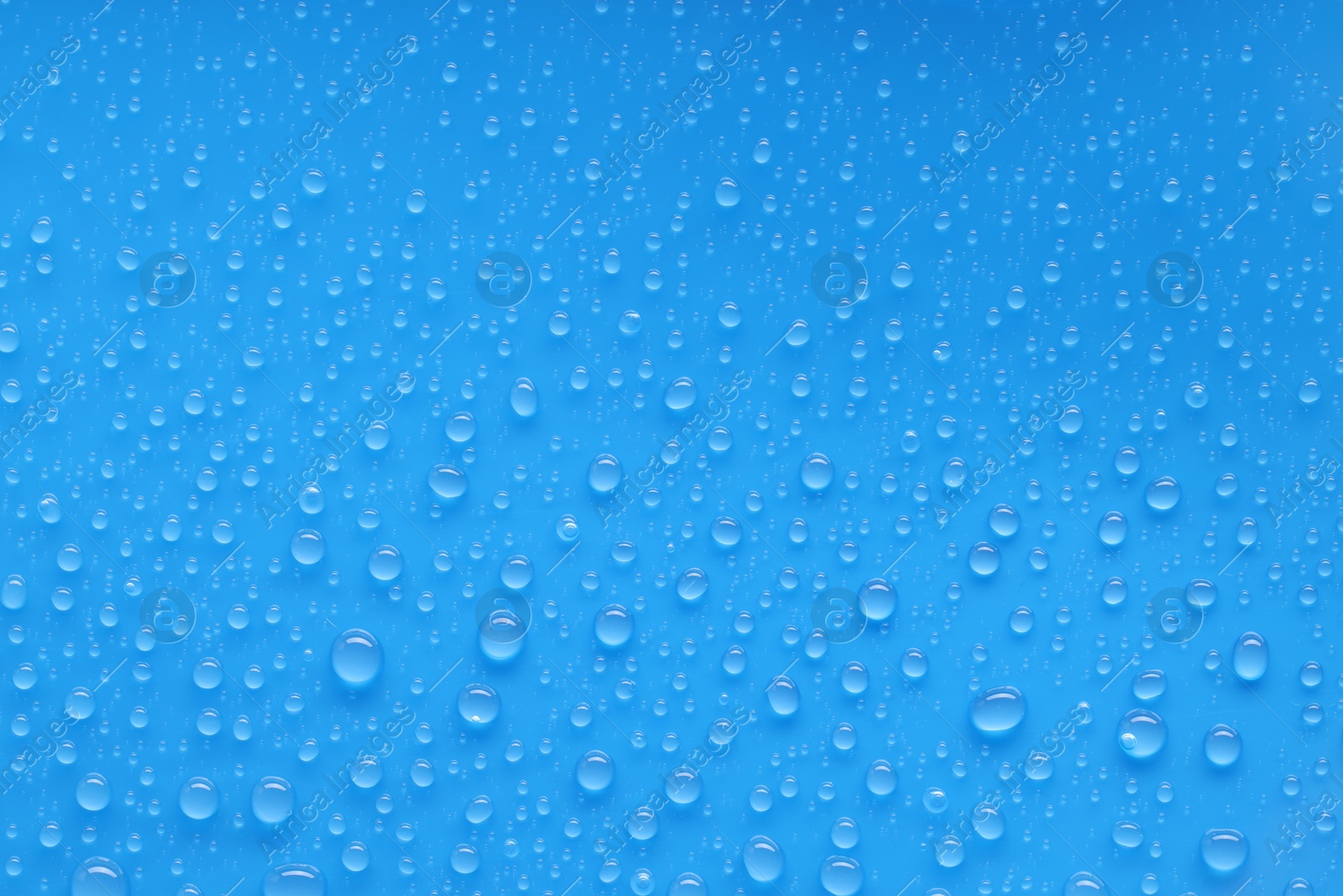 Photo of Water drops on blue background, top view