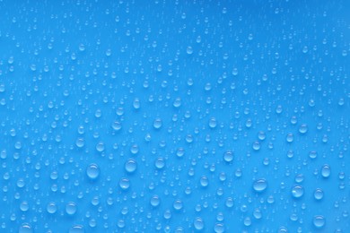 Photo of Water drops on blue background, top view