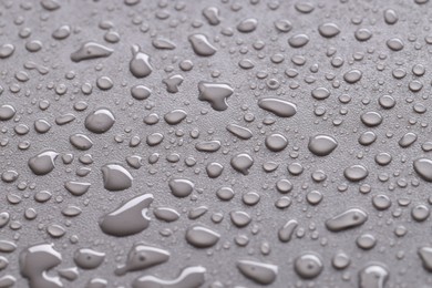 Photo of Water drops on gray background, closeup view