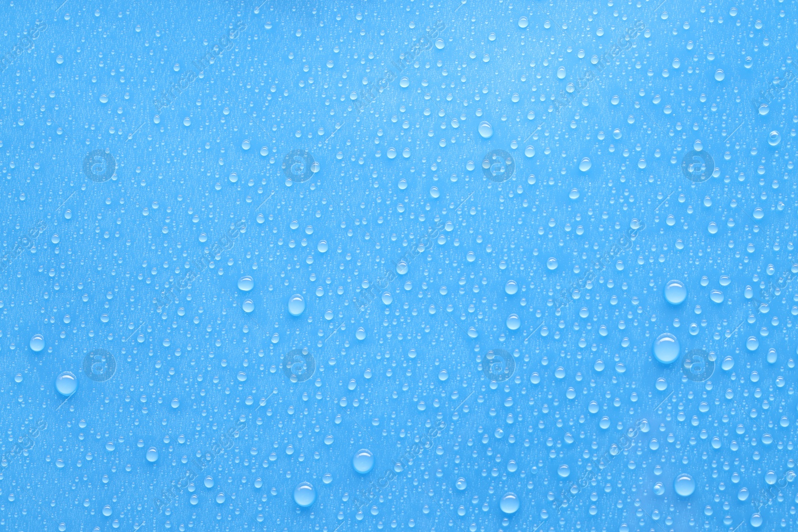 Photo of Water drops on light blue background, top view