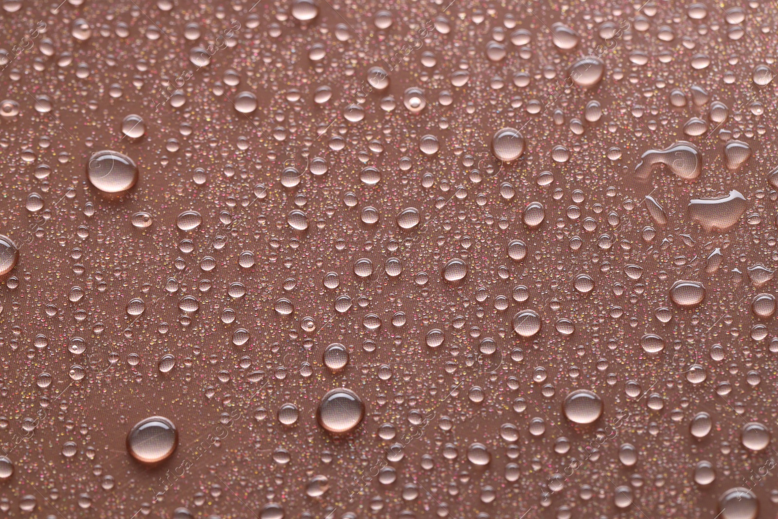 Photo of Water drops on brown background, closeup view