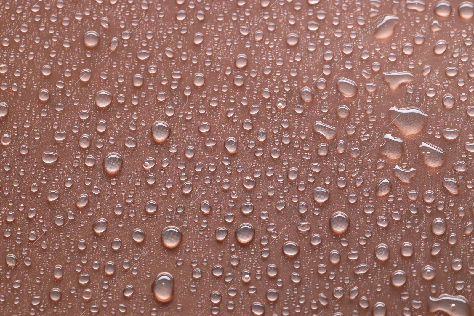 Photo of Water drops on brown background, top view