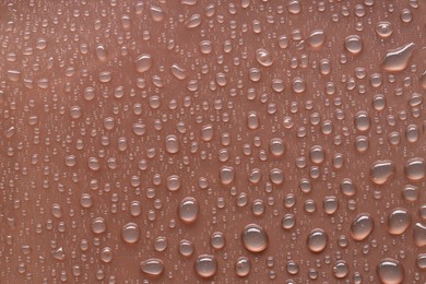 Photo of Water drops on brown background, top view