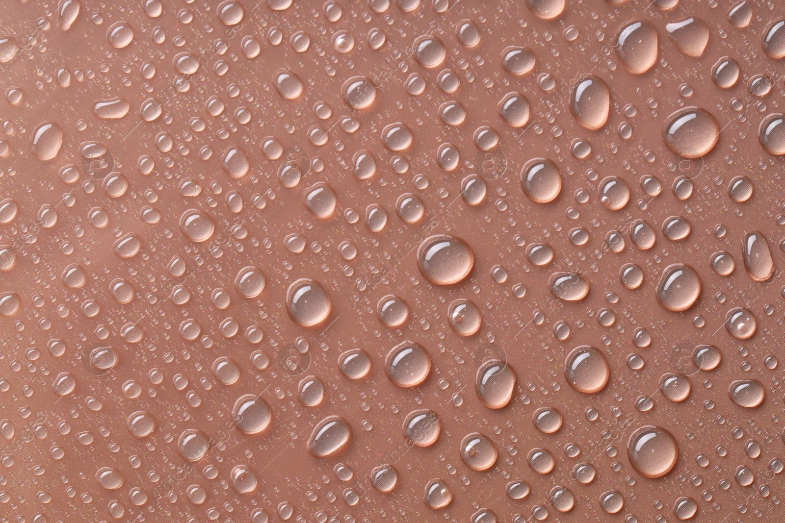 Photo of Water drops on brown background, top view