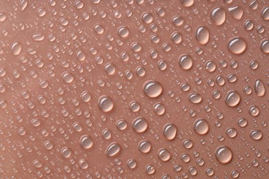 Photo of Water drops on brown background, top view