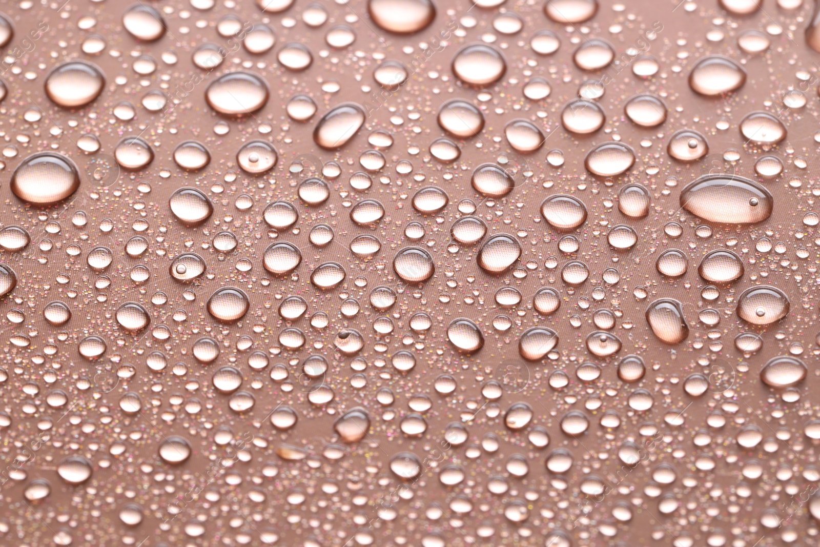 Photo of Water drops on brown background, closeup view