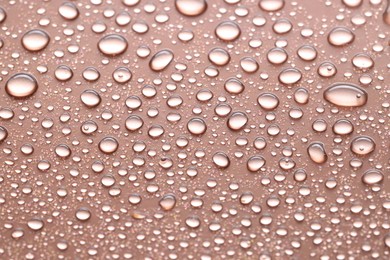 Photo of Water drops on brown background, closeup view