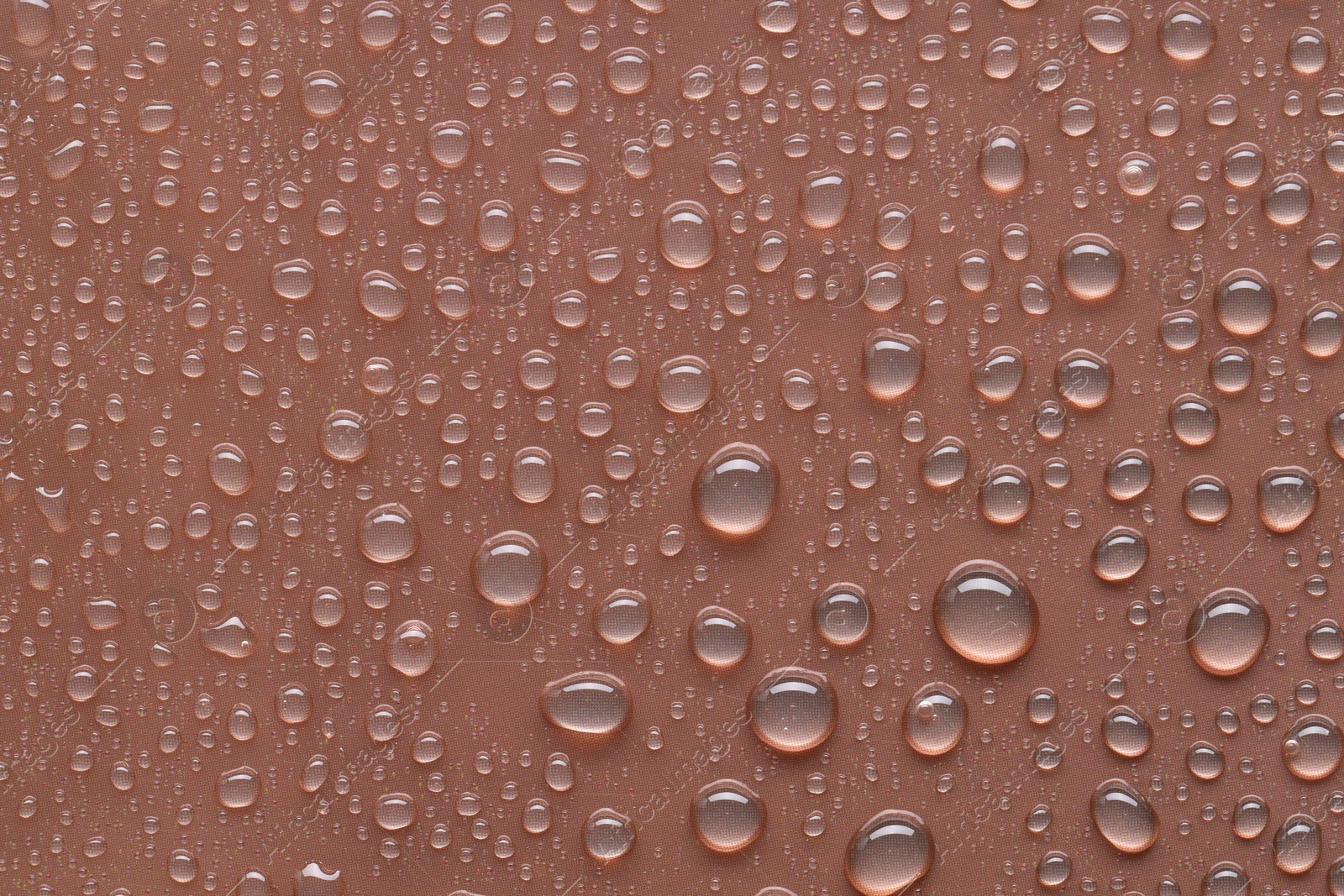 Photo of Water drops on brown background, top view