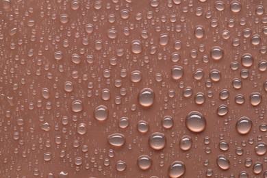 Photo of Water drops on brown background, top view