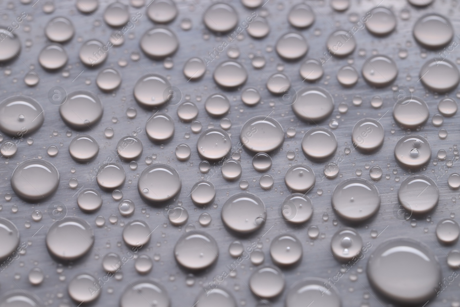 Photo of Water drops on gray background, closeup view