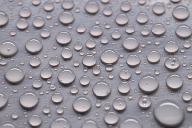 Photo of Water drops on gray background, closeup view