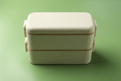 Photo of New plastic lunch box on green background