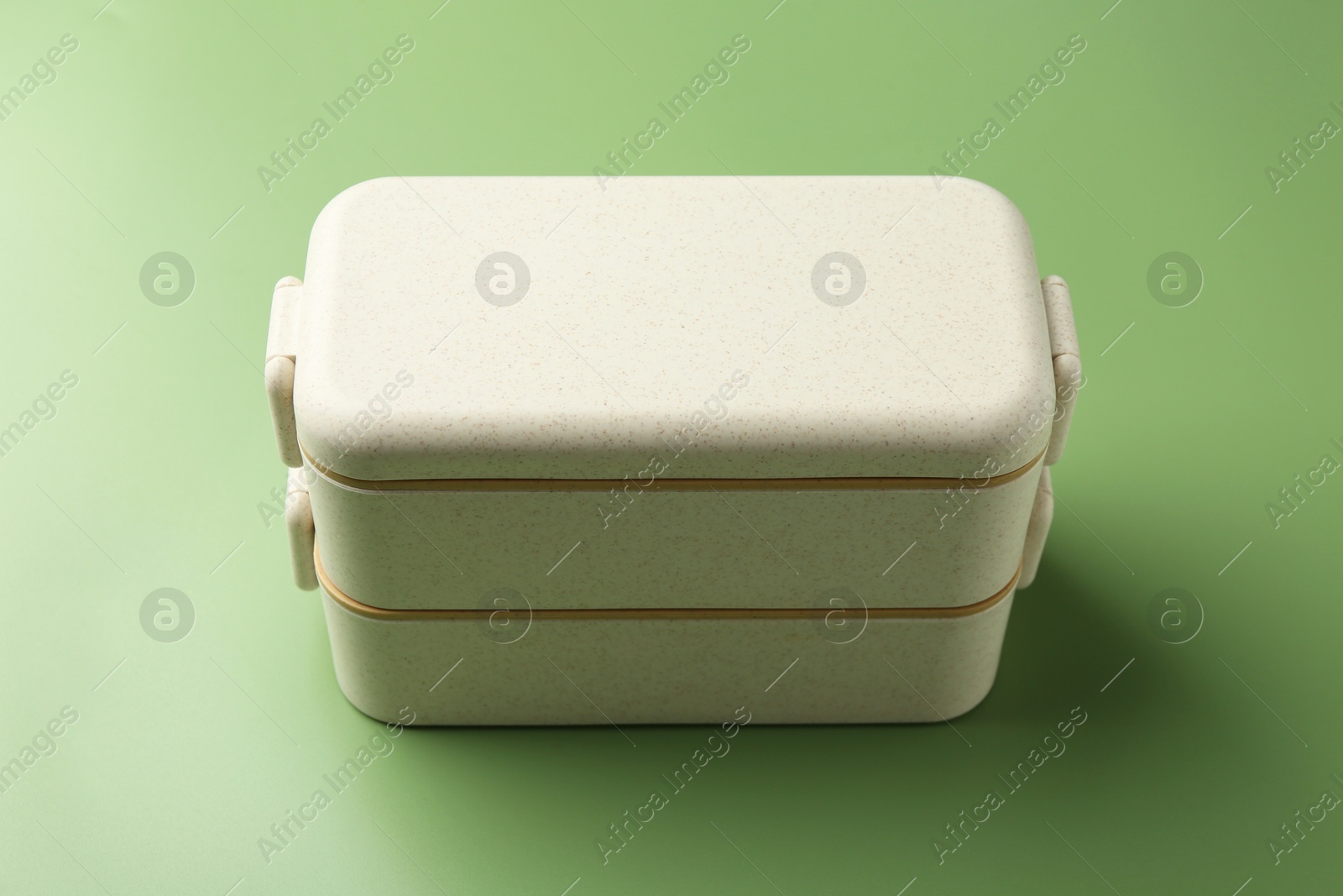 Photo of New plastic lunch box on green background