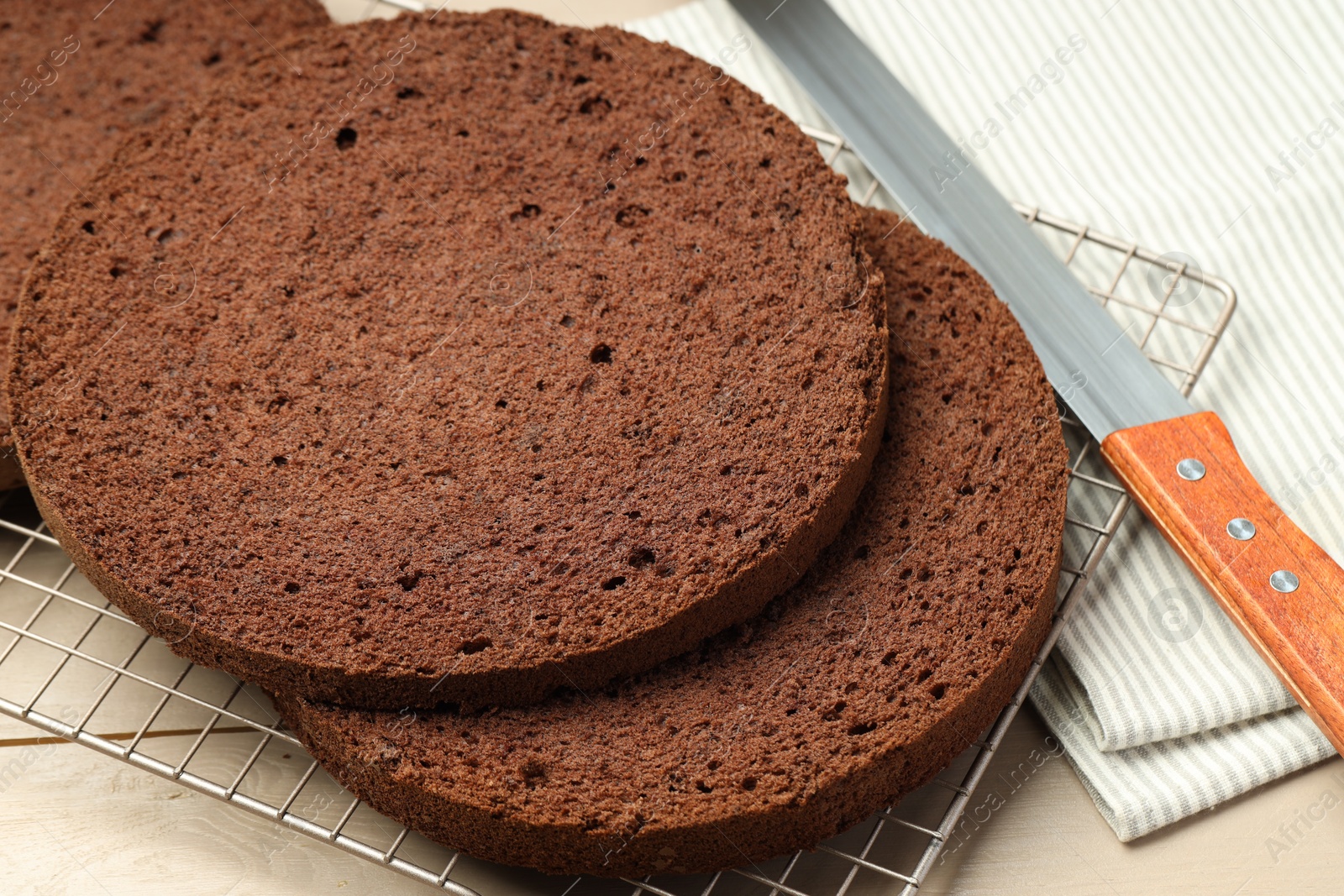 Photo of Cut tasty chocolate sponge cake and knife on wooden table, closeup