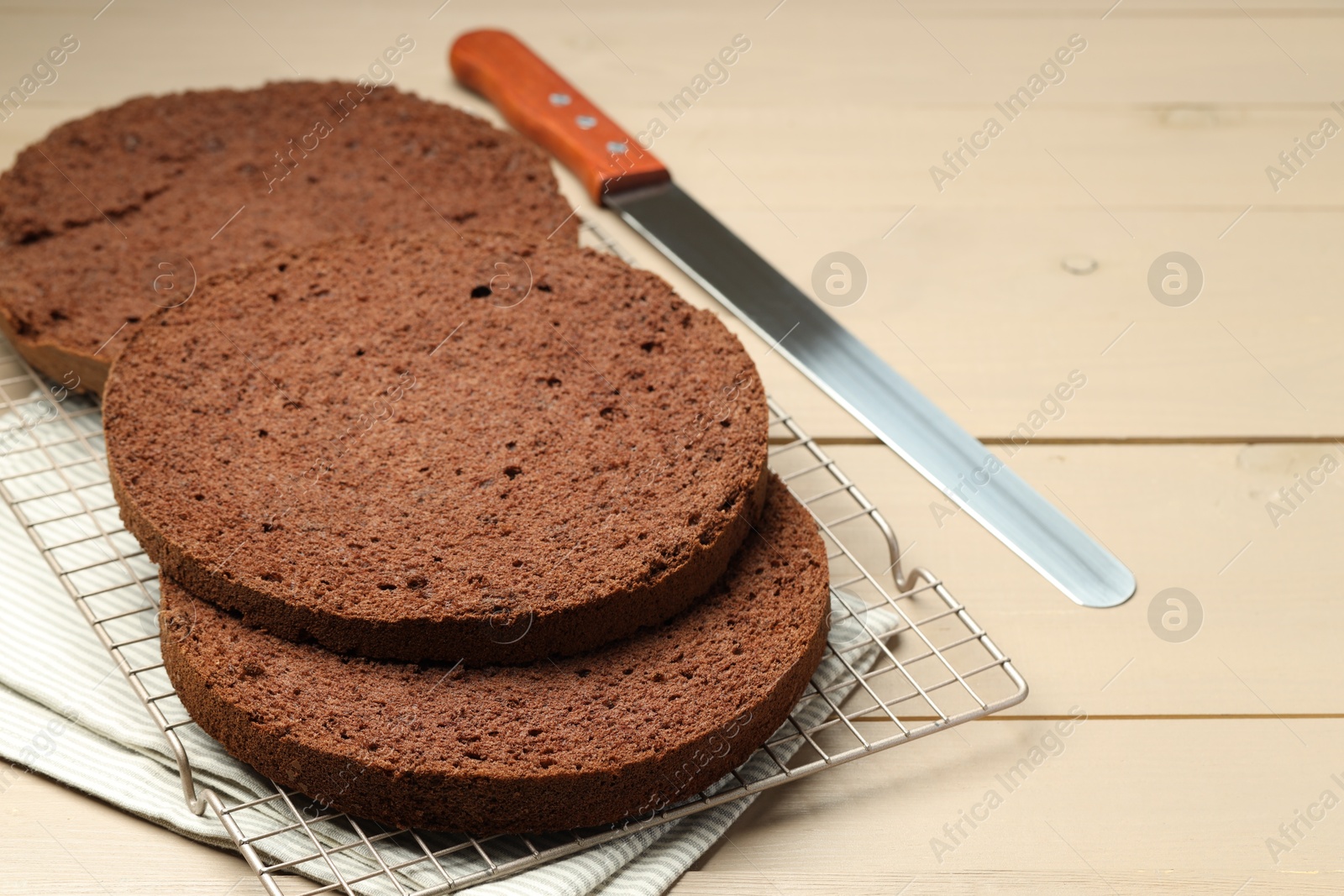 Photo of Cut tasty chocolate sponge cake and knife on wooden table, closeup