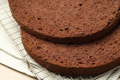 Photo of Cut tasty chocolate sponge cake on wooden table, closeup