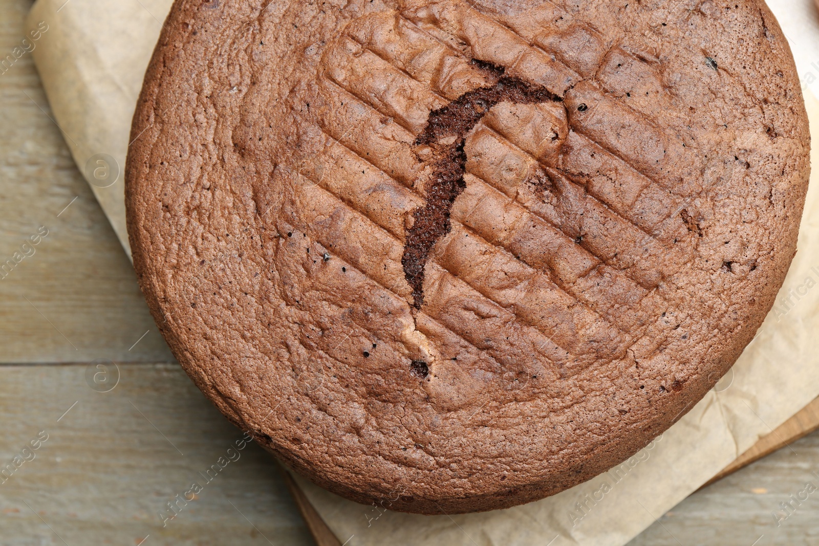 Photo of Tasty chocolate sponge cake on wooden table, top view