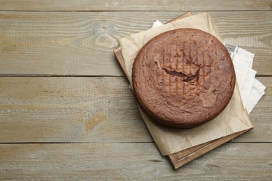 Photo of Tasty chocolate sponge cake on wooden table, top view. Space for text