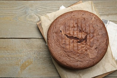 Photo of Tasty chocolate sponge cake on wooden table, top view. Space for text