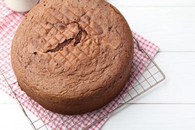 Photo of Tasty chocolate sponge cake on white wooden table, closeup