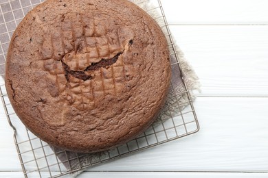 Photo of Tasty chocolate sponge cake on white wooden table, top view