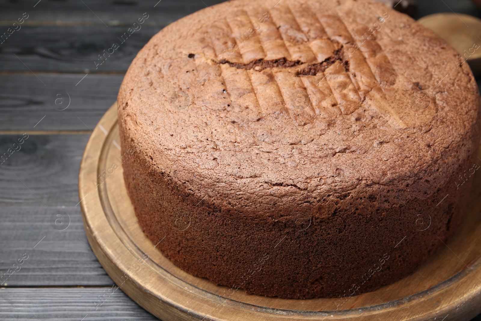 Photo of Tasty chocolate sponge cake on black wooden table, closeup