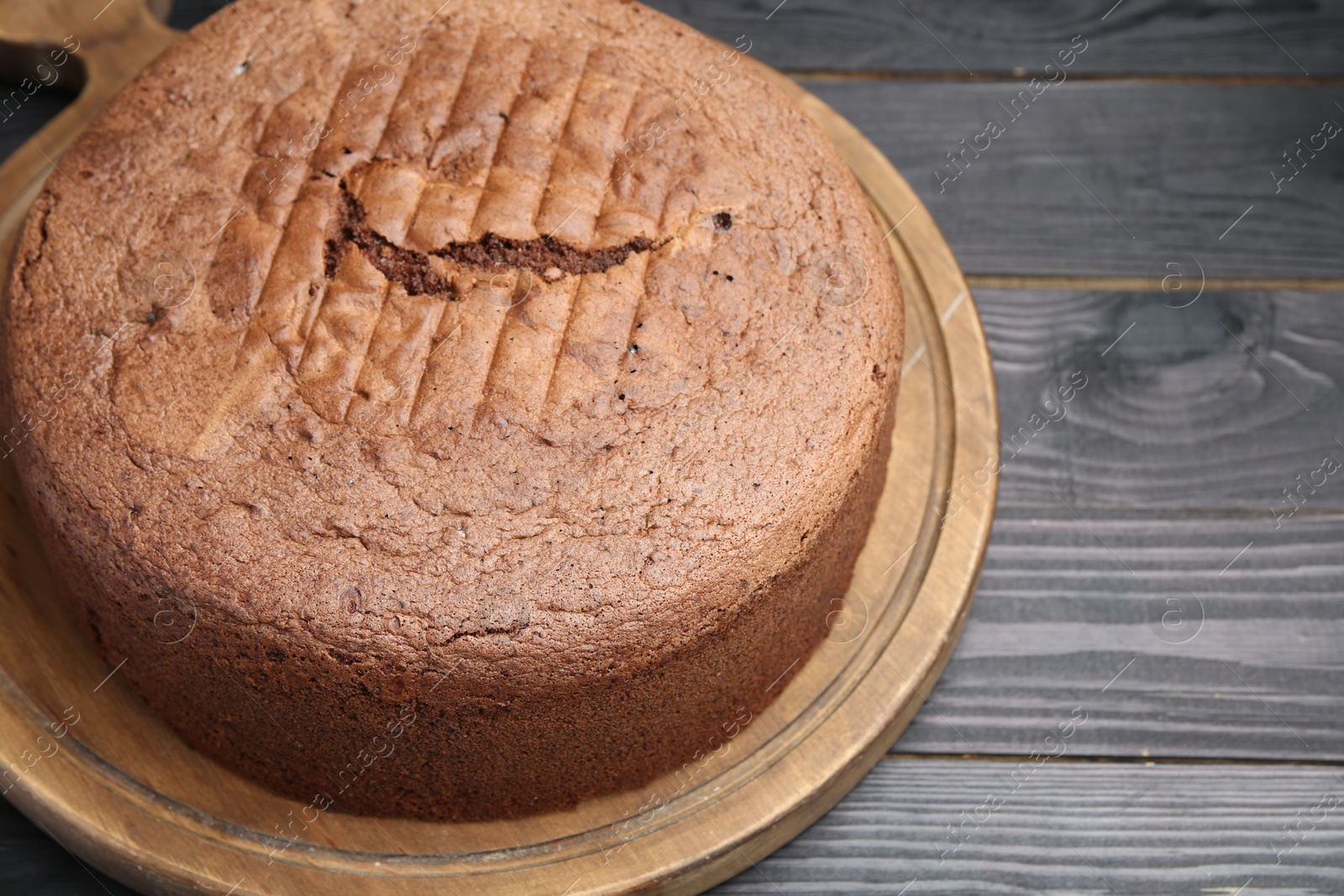 Photo of Tasty chocolate sponge cake on black wooden table, closeup