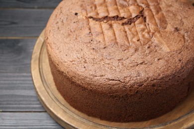 Photo of Tasty chocolate sponge cake on black wooden table, closeup