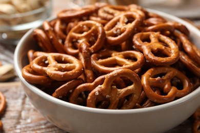 Photo of Delicious salty pretzel crackers on wooden table, closeup